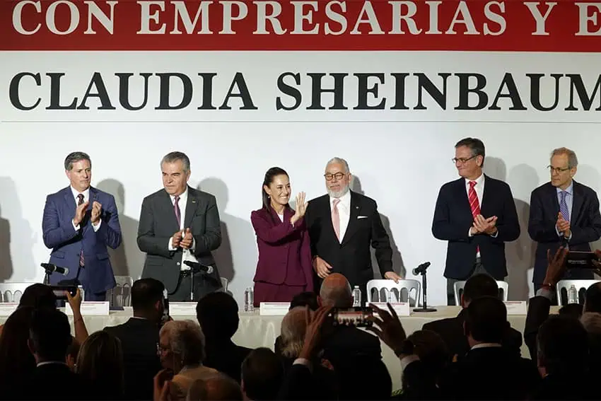 Claudia Sheinbaum and business leaders standing behind a banquet table