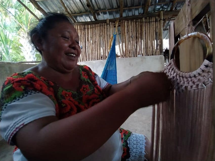 María Enedina Canul Poot, founder of the Amazonas softball team, wears a huipil while weaving in her home.