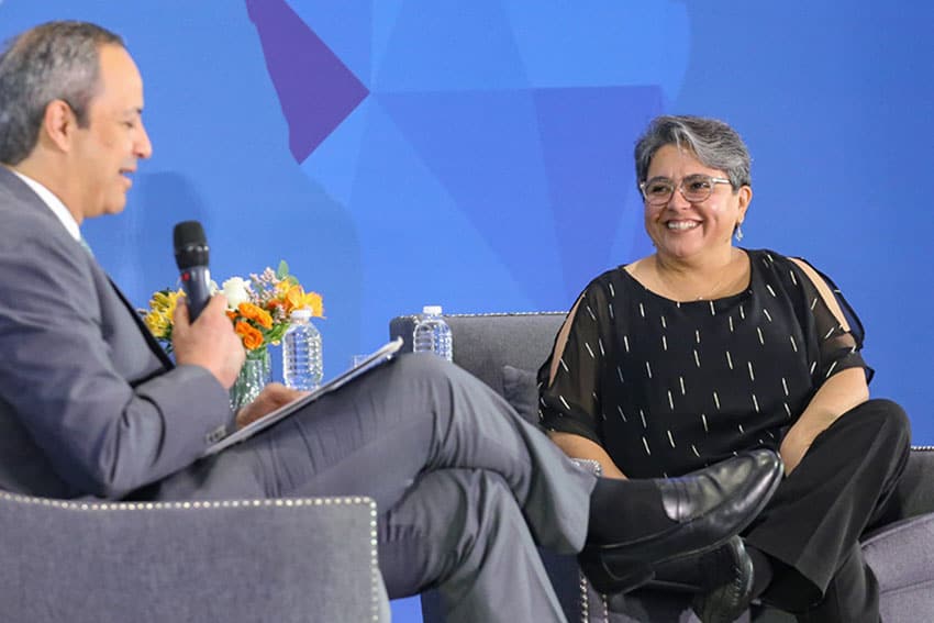 Mexico's Economy Minister Raquel Buenrostro being interviewed onstage by a man holding a microphone