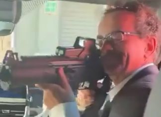 Former U.K. ambassador to Mexico Jonathan Benjamin points an assault rifle at the camera in a blurry video screenshot